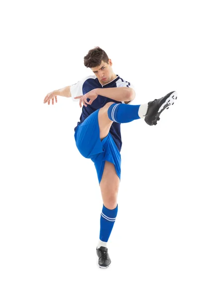 Jogador de futebol em camisa azul chutando — Fotografia de Stock