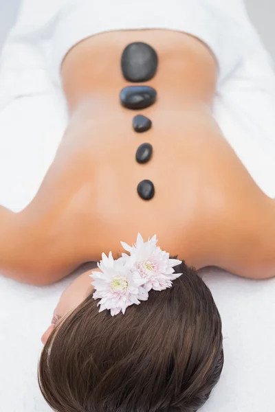 Beautiful woman receiving stone massage at spa center — Stock Photo, Image