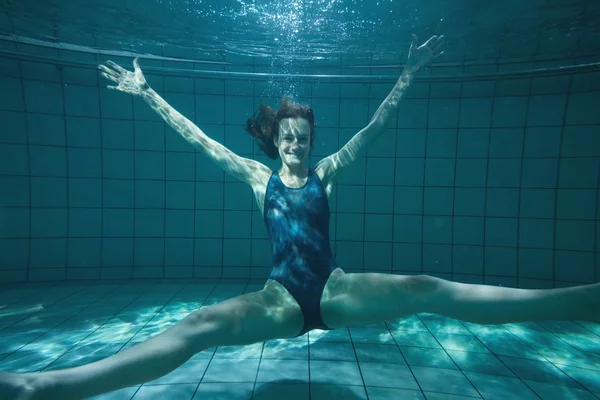 Nadador atlético posando para la cámara y sonriendo bajo el agua — Foto de Stock