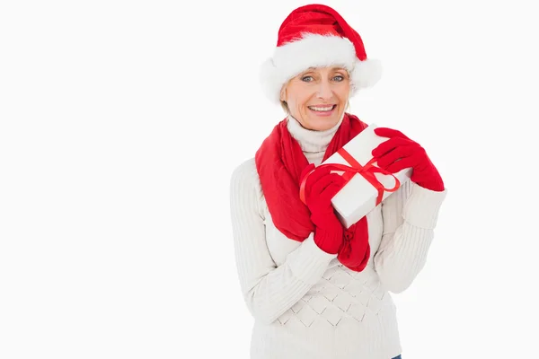 Mujer festiva sonriendo a la cámara sosteniendo un regalo —  Fotos de Stock