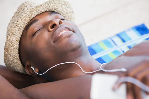 Uomo senza maglietta che sorride e ascolta musica — Foto Stock