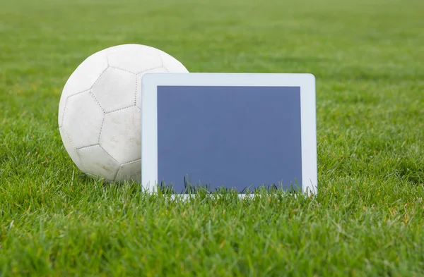 Fútbol y tableta con pantalla en blanco en el terreno de juego —  Fotos de Stock