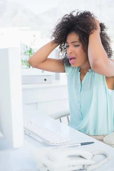 Casual zakenvrouw benadrukkend uit op haar Bureau — Stockfoto