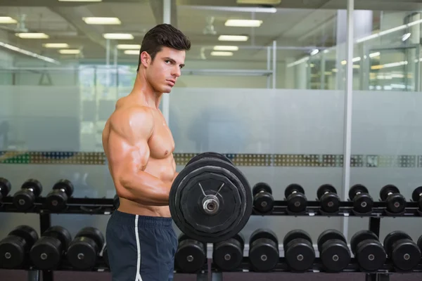 Shirtless muscular man lifting barbell in gym — Stock Photo, Image