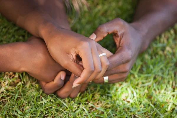 Paar bedrijf handen op het gras — Stockfoto