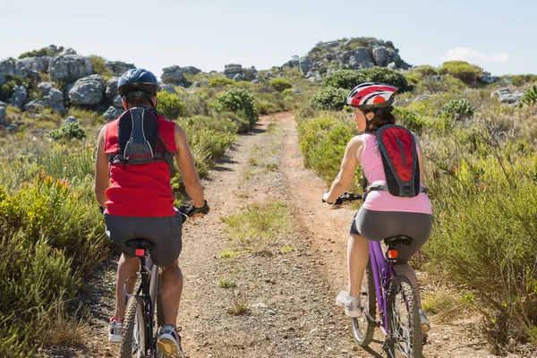 Ativo casal de ciclismo no campo — Fotografia de Stock