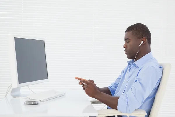 Businessman listening to music while he works — Stock Photo, Image