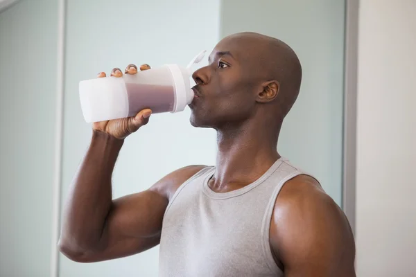 Uomo sportivo che beve proteine in palestra — Foto Stock