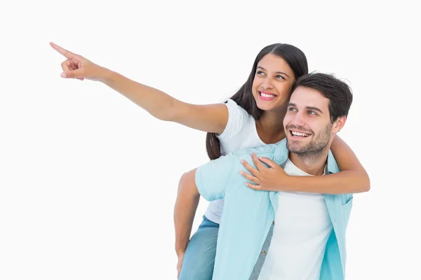 Happy casual man giving pretty girlfriend piggy back — Stock Photo, Image