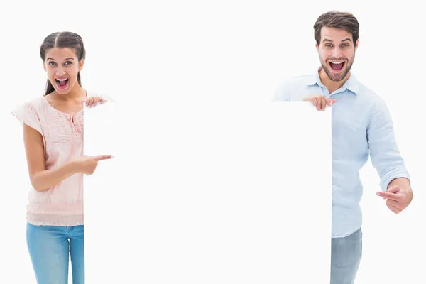 Casal jovem atraente sorrindo e segurando cartaz — Fotografia de Stock