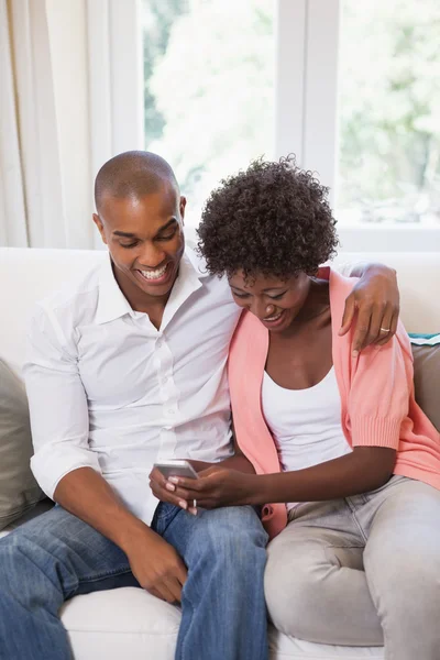 Paar entspannt mit Smartphone auf der Couch — Stockfoto