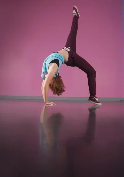 Hübsche Breakdancerin beugt sich mit erhobenem Bein nach hinten — Stockfoto