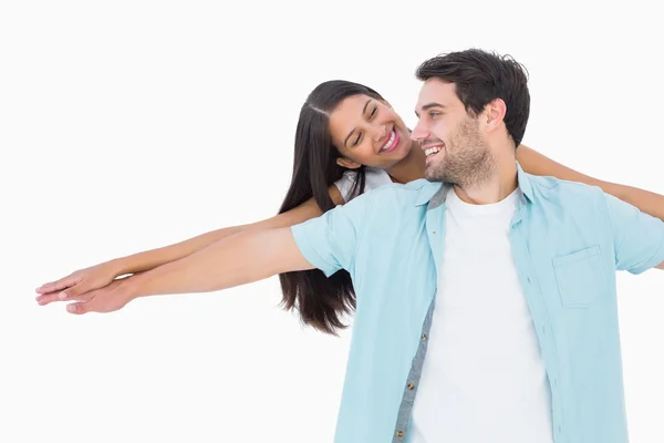 Feliz casual homem dando bonito namorada porquinho de volta — Fotografia de Stock