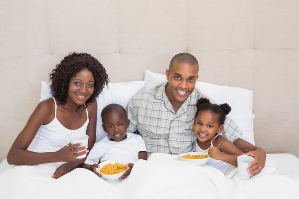 Familia feliz desayunando juntos en la cama por la mañana —  Fotos de Stock