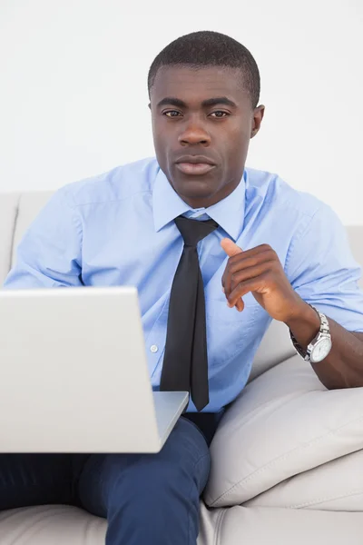 Schöner Geschäftsmann mit Laptop auf dem Sofa — Stockfoto