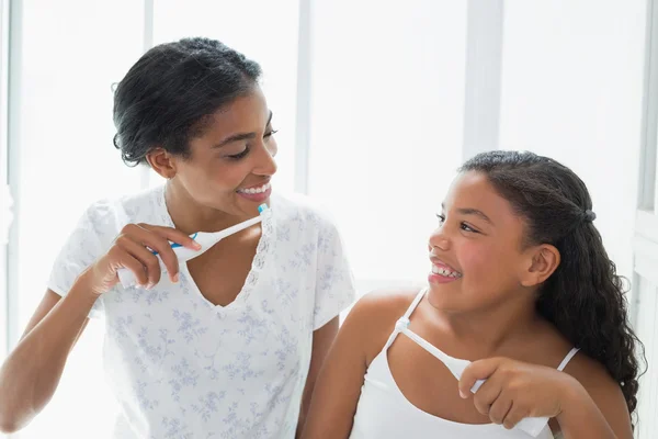 Pretty mother brushing her teeth with her daughter — Stock Photo, Image