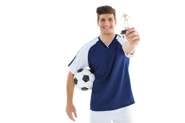 Jugador de fútbol en camiseta azul con trofeo de ganadores — Foto de Stock