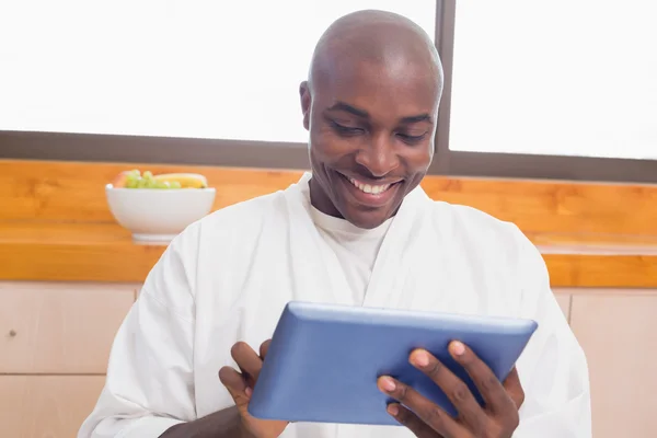 Homem feliz em roupão de banho usando tablet pc — Fotografia de Stock