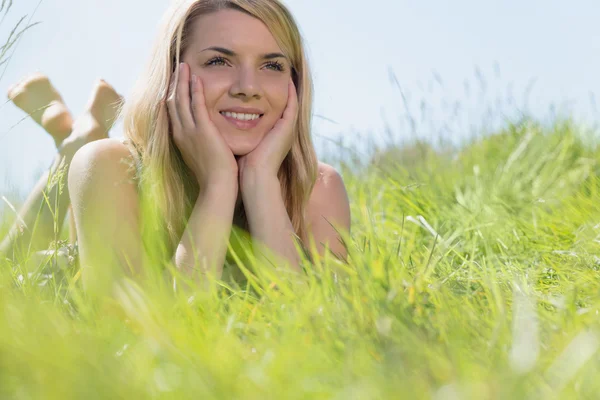 Bonita rubia en vestido de sol acostada en la hierba sonriendo —  Fotos de Stock