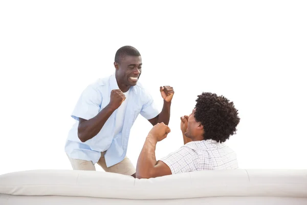 Happy sports fans cheering at the couch — Stock Photo, Image