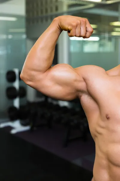 Nahaufnahme eines muskulösen Mannes, der die Muskeln spielen lässt — Stockfoto