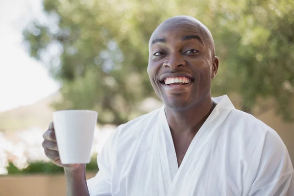 Knappe man in badjas met koffie buiten — Stockfoto