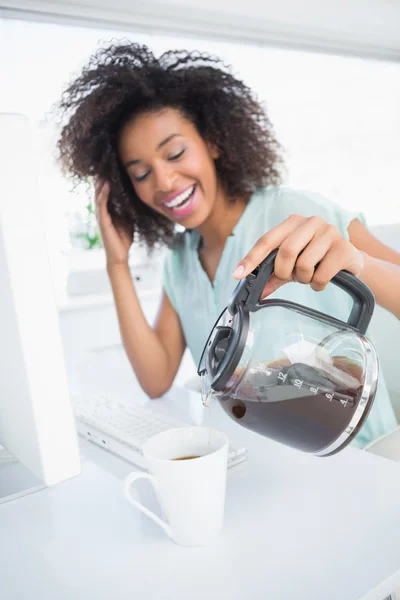 Donna d'affari stanca che versa una tazza di caffè alla scrivania — Foto Stock