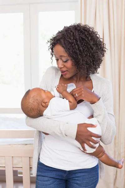 Gelukkig moeder voeden haar babyjongen zijn fles — Stockfoto