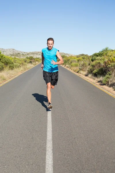 Adatto uomo che fa jogging sulla strada aperta — Foto Stock