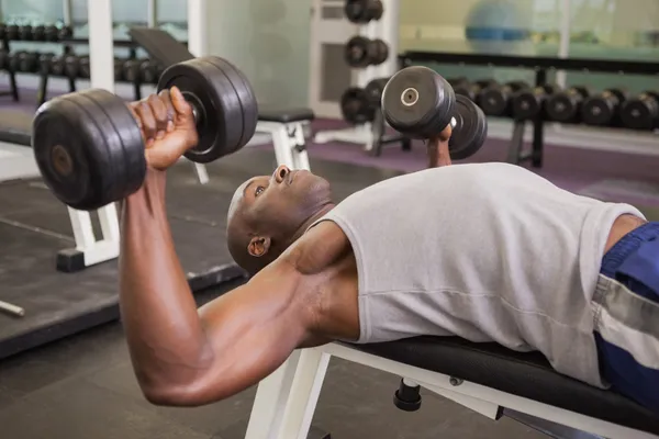 Homem muscular exercitando com halteres — Fotografia de Stock