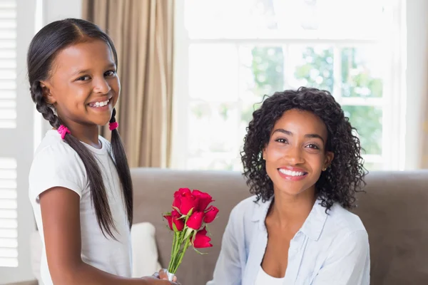 Vackra mamma med sin dotter erbjuder rosor — Stockfoto