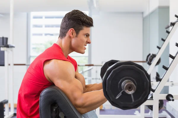 Musculoso hombre levantando barra en gimnasio — Foto de Stock