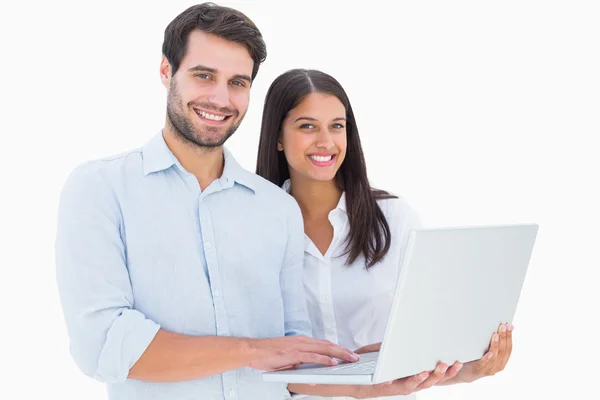 Attractive young couple holding their laptop — Stock Photo, Image