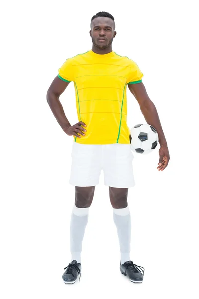 Футболист в желтом стоя с мячом — стоковое фото