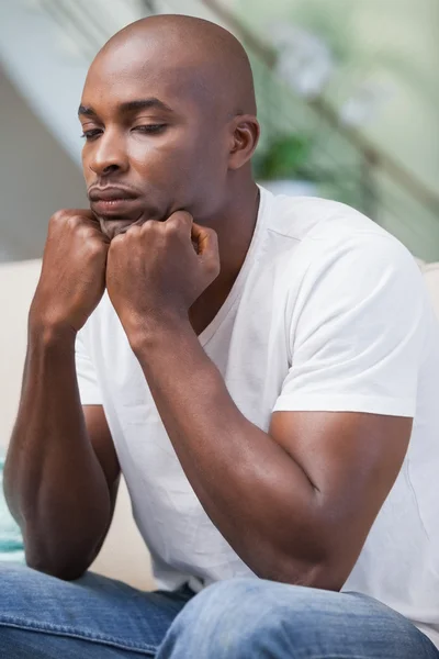 Jeune homme bouleversé assis sur le canapé — Photo