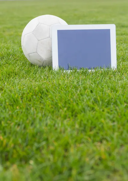 Fútbol y tableta con pantalla en blanco en el terreno de juego —  Fotos de Stock