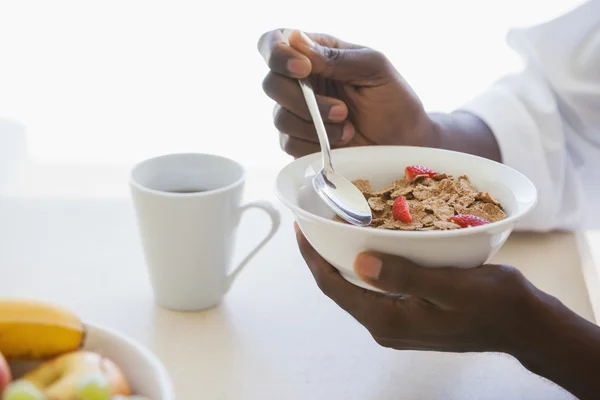 Man eating bowl of cereal outside — Stock Photo, Image