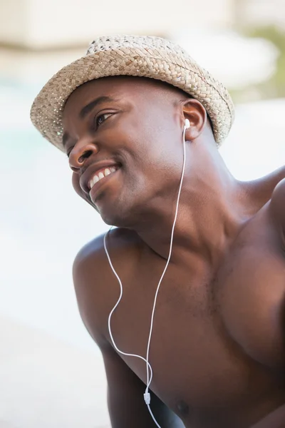 Uomo senza maglietta che sorride e ascolta musica — Foto Stock
