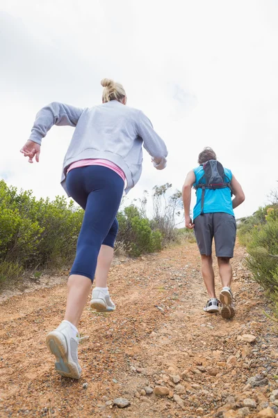 Couple jogging up mountain trail — Stock Photo, Image