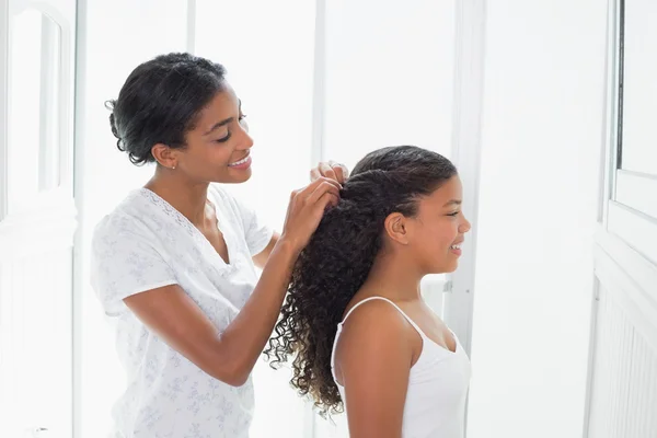 Bella madre legare i capelli figlie indietro — Foto Stock