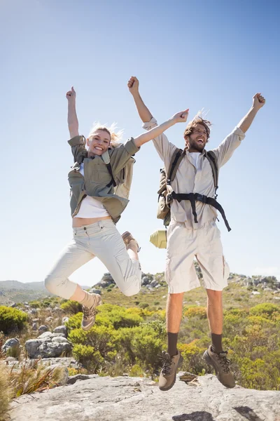 Couple on mountain terrain jumping — Stock Photo, Image