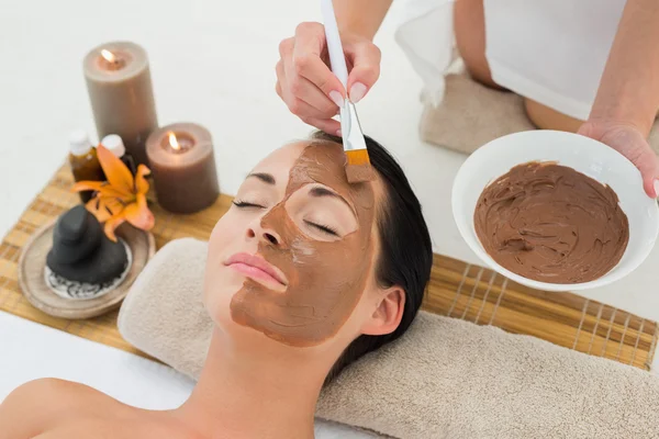 Peaceful brunette getting a mud facial applied — Stock Photo, Image