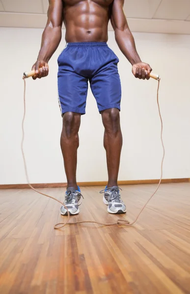 Shirtless muscular man skipping in gym — Stock Photo, Image