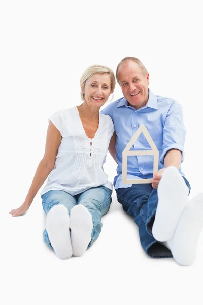 Glad äldre par hålla formen hus — Stockfoto