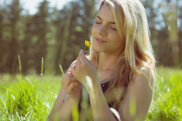 Loira bonita em sundress segurando flor amarela — Fotografia de Stock