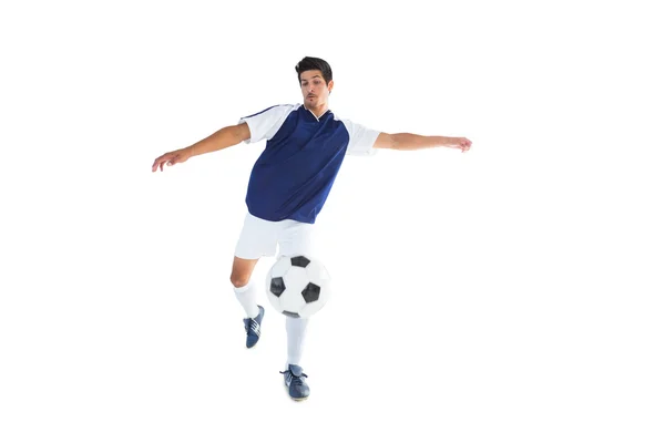 Football player in blue kicking ball — Stock Photo, Image