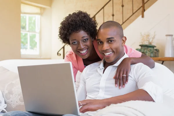 Cute couple relaxing on couch with laptop — Stock Photo, Image