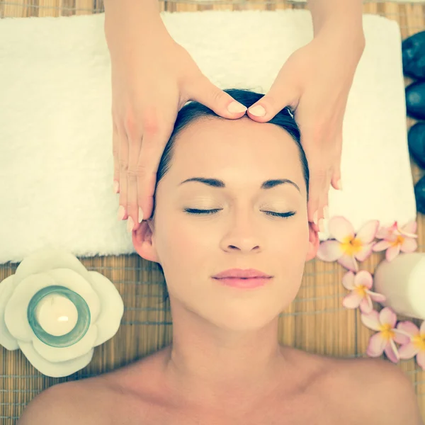 Smiling brunette enjoying a head massage — Stock Photo, Image