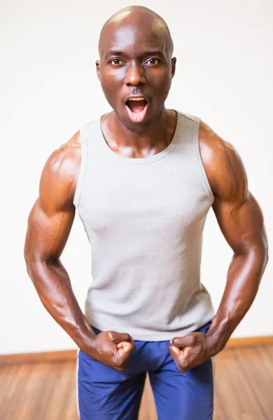 Muscular hombre gritando mientras flexiona los músculos —  Fotos de Stock