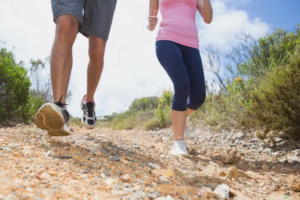 Couple running down mountain trail — Stock Photo, Image